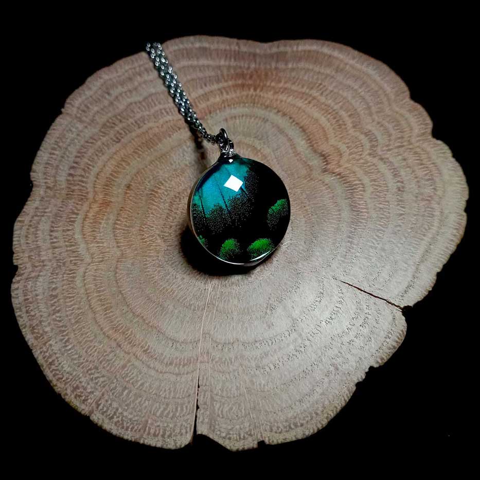 Collana con ala di farfalla Papilio lorquinianus con lente rotonda in vetro che mostra un’ala verde mare di farfalla macaone trasformata in gioiello