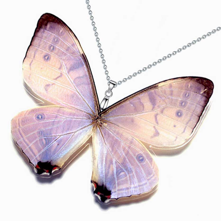 Farfalla Morpho sulkowskyi con ali bianco perlaceo e blu iridescente nella foresta nebulosa, ispirazione per collana con vera ala di farfalla