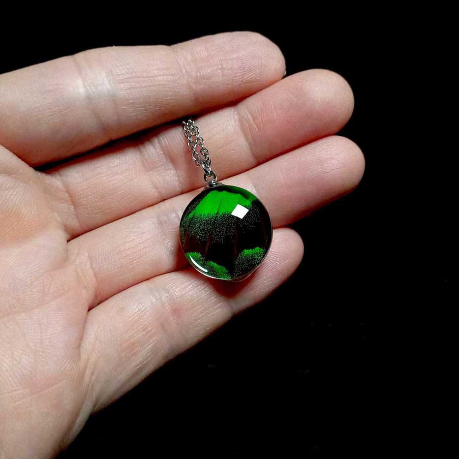 Collana con vera ala di farfalla Papilio palinurus mostrata sulla mano con ciondolo con ala verde smeraldo